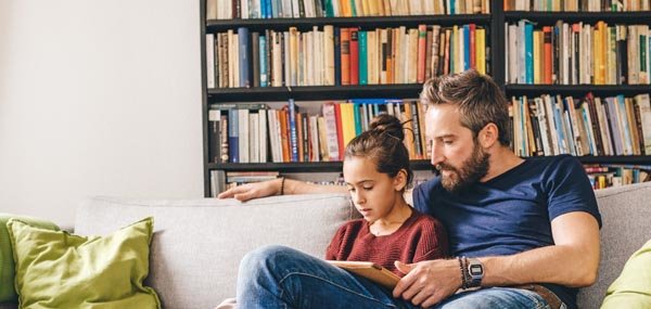 father reading with daughter on couch mobile