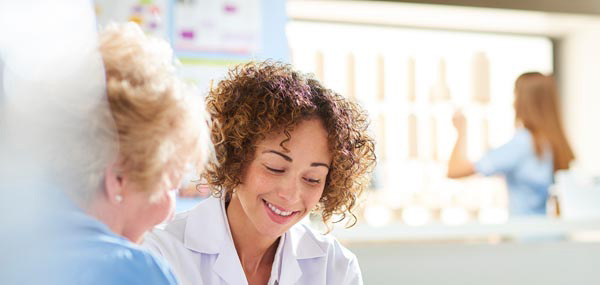 female doctor with older woman patient mobile